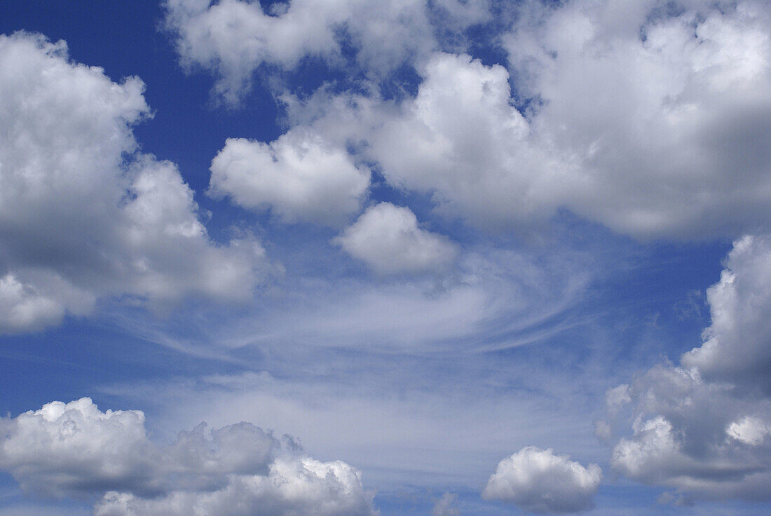 On this beautiful summer day white puffy clouds float around in a deep blue sky