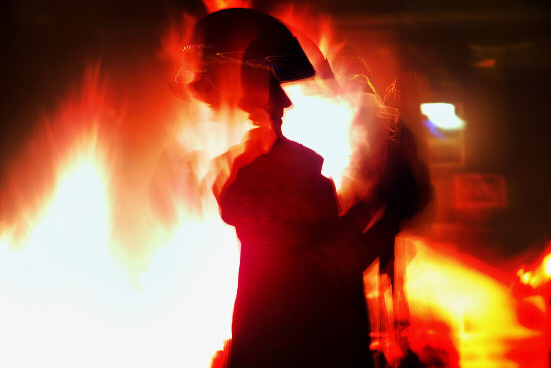 Firefighter preparing to extinguish a huge fire.