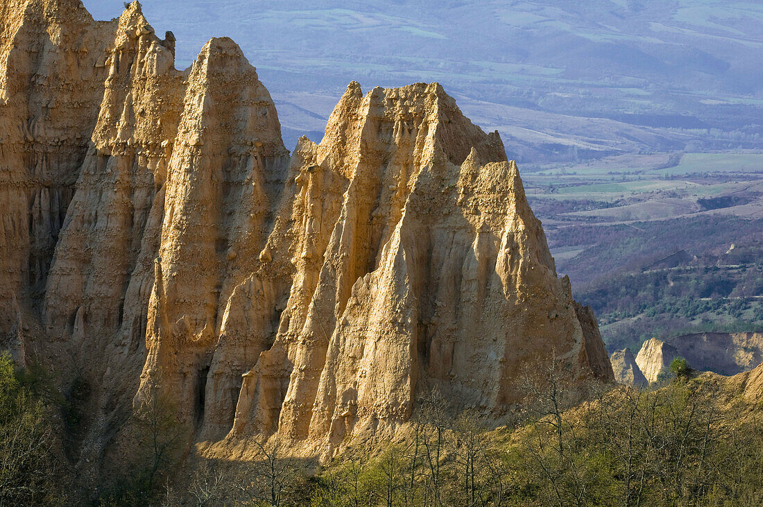 Hoodoo rocks of Melnik, geologic formations of soft sedimentary rocks, overlooking cultivated  landscape of Bistrica Valley, South Bulgaria