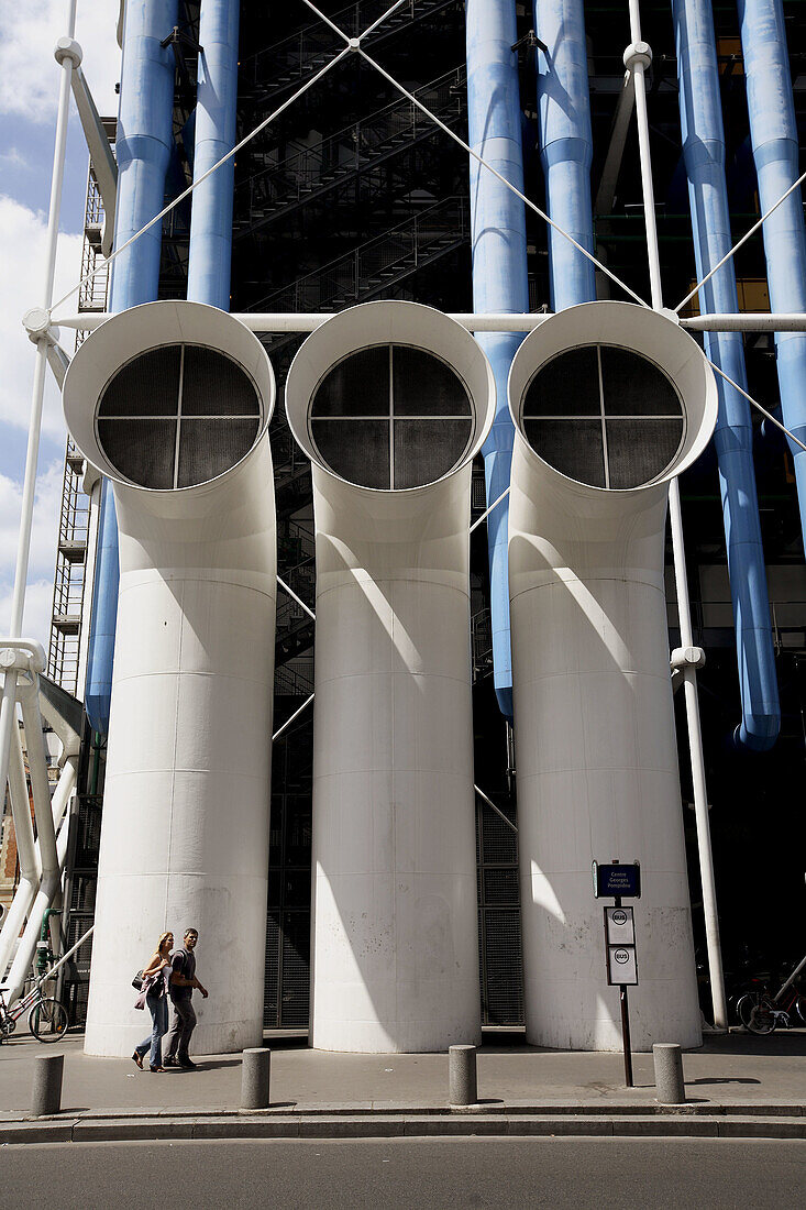 France. Paris. Pedestrians walk under the huge funnels of Pompidou Centre in Rue Beaubourg.