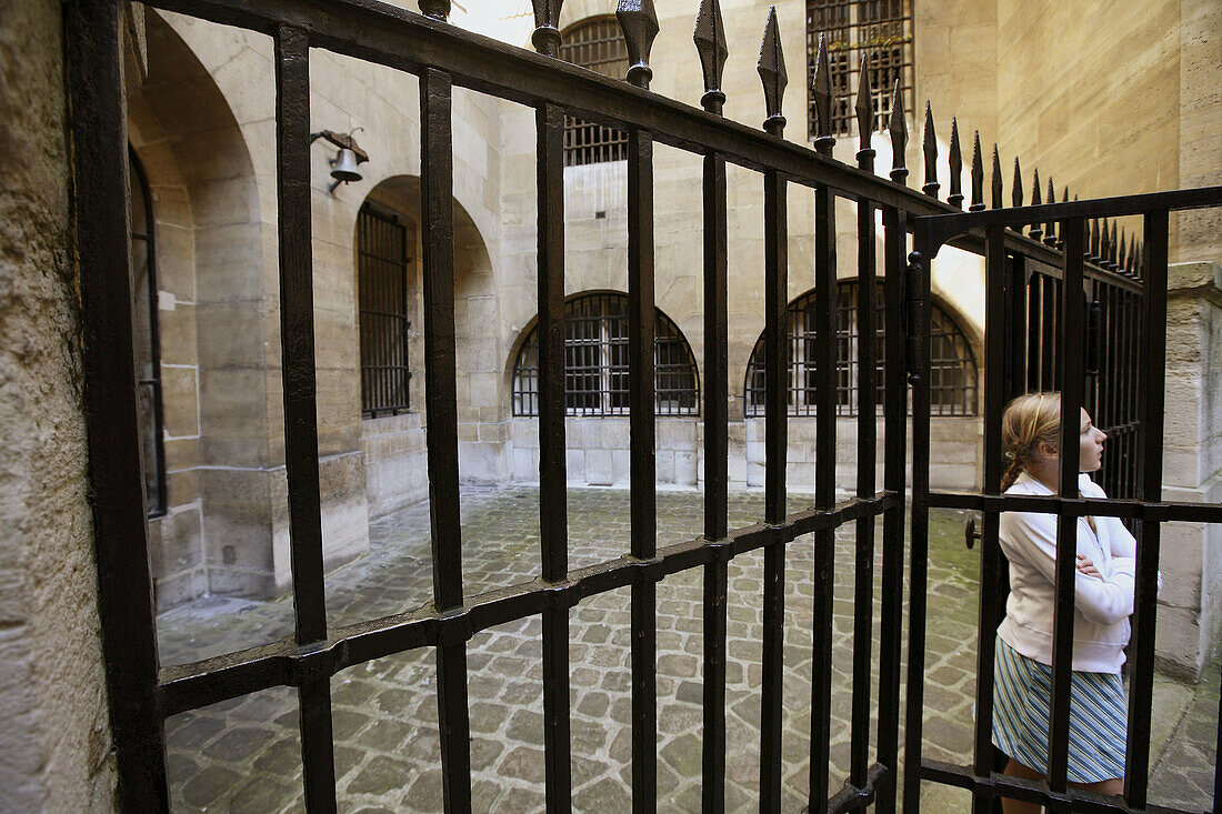 France. Paris. A young girl in the historical prison courtyard in the Conciergerie.