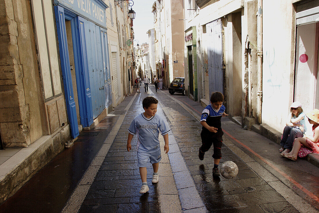 French. Provence. Marseille. Two local boys playing football in a street of Panier Quarter.