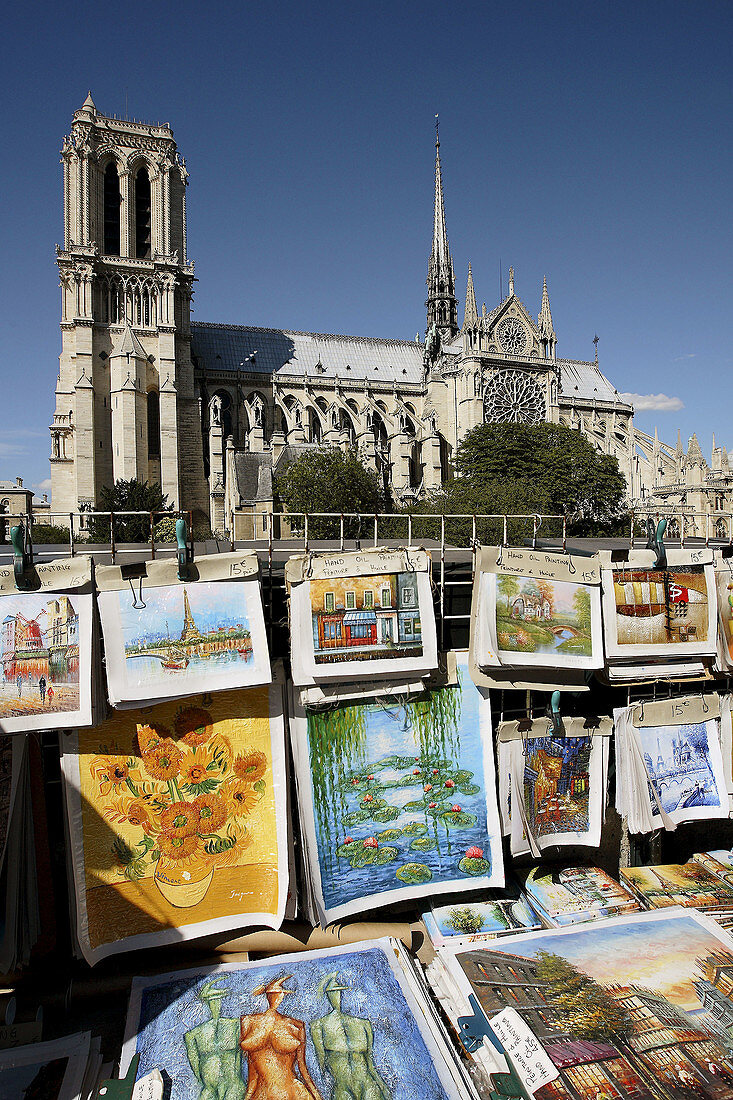 France. Paris. Posters for sale on the roadside with Notre_Dame Cathedral in the background.
