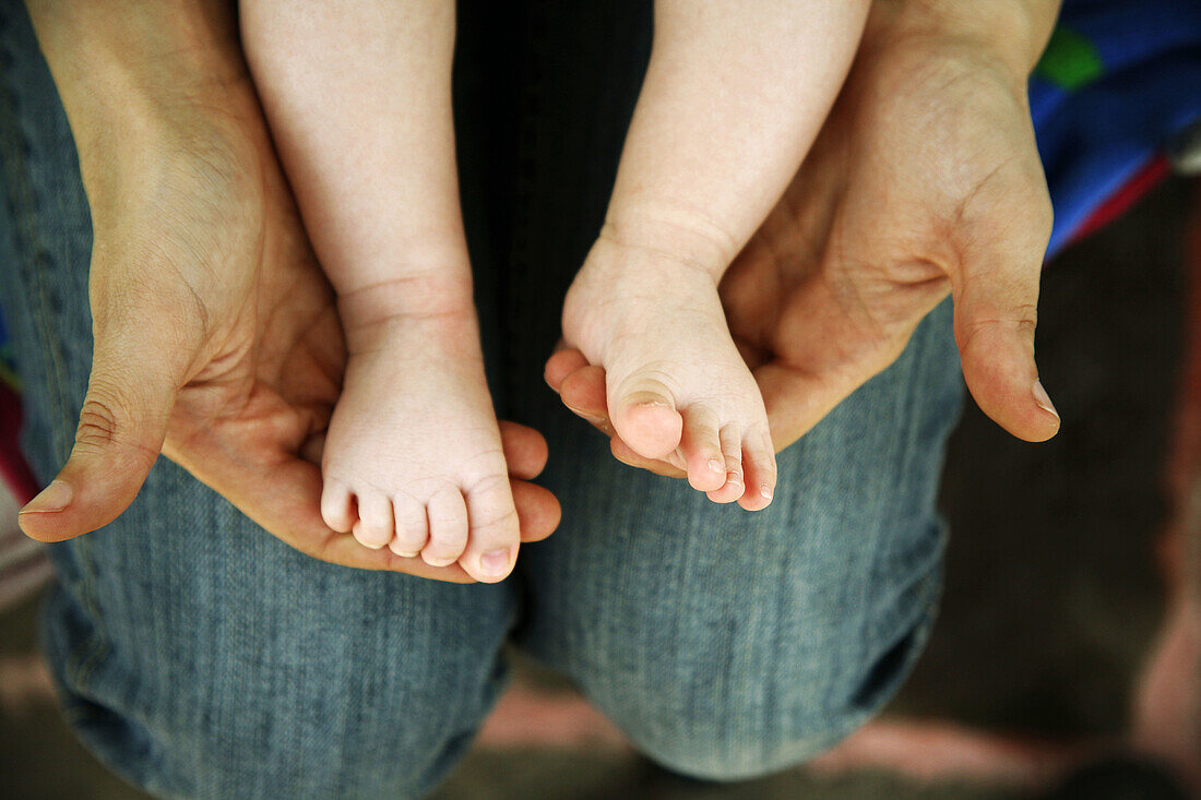 Mother touching the feet of his baby