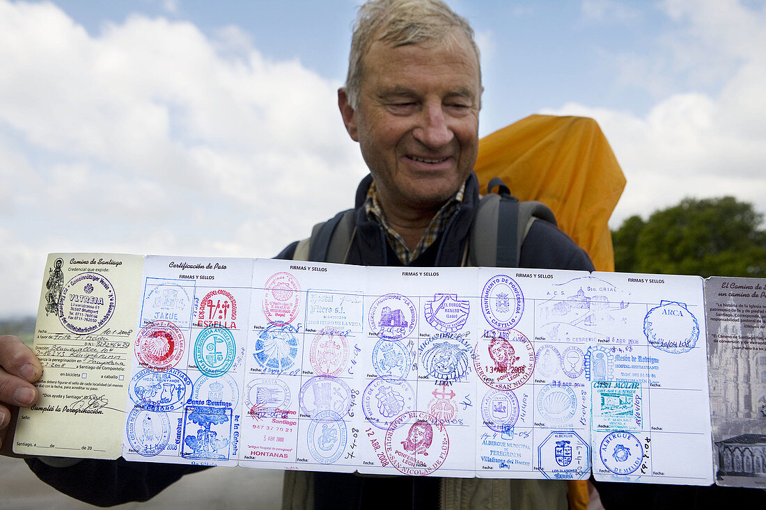 Man showing his St. James pilgrim passport stamps, Santiago de Compostela. La Coruña province, Galicia, Spain