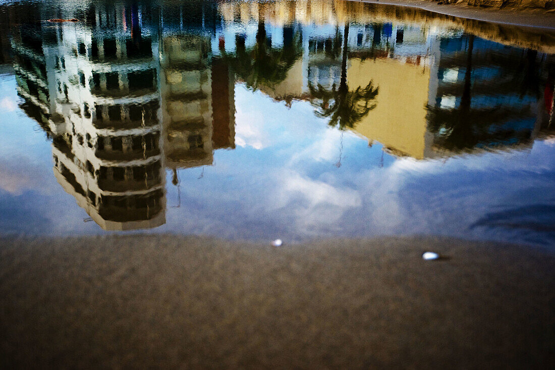 Edificios y palmeras reflejados en el agua. Costa Dorada, Cataluña. Spain