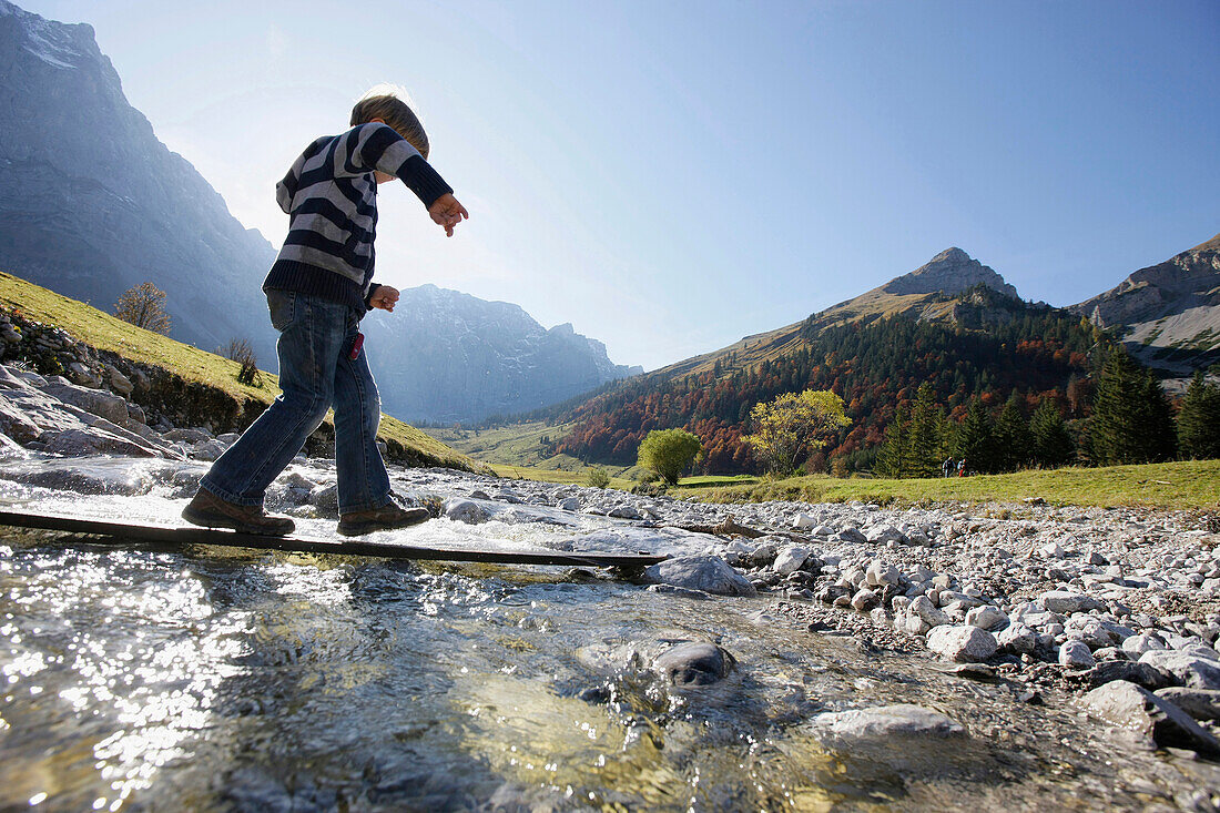 Boy passing Rißbach creek, Eng, Tyrol, Austria