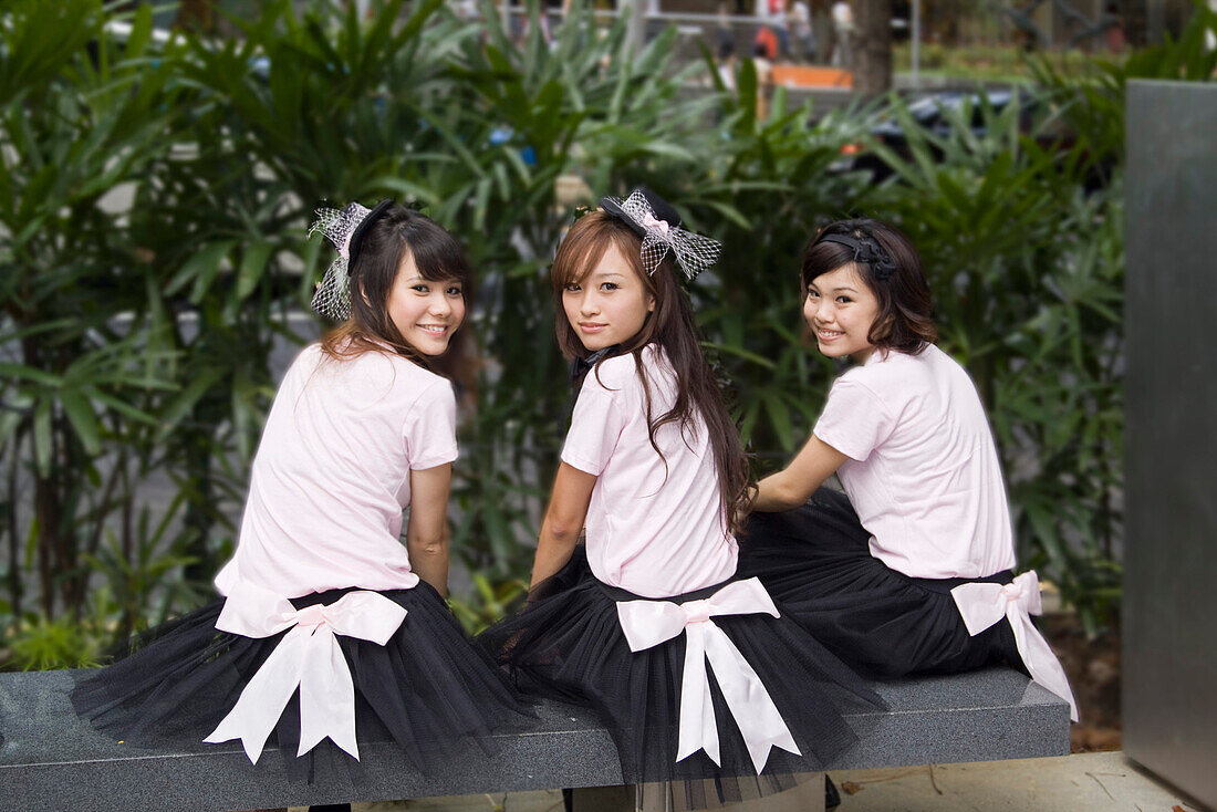 Orchard Road, Einkaufsmeile, froehliche Maedchen  auf Bank, Singapur Asien
