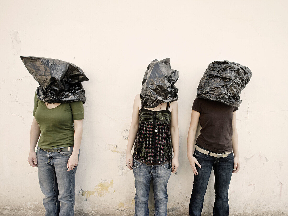 Three women with bags over their heads