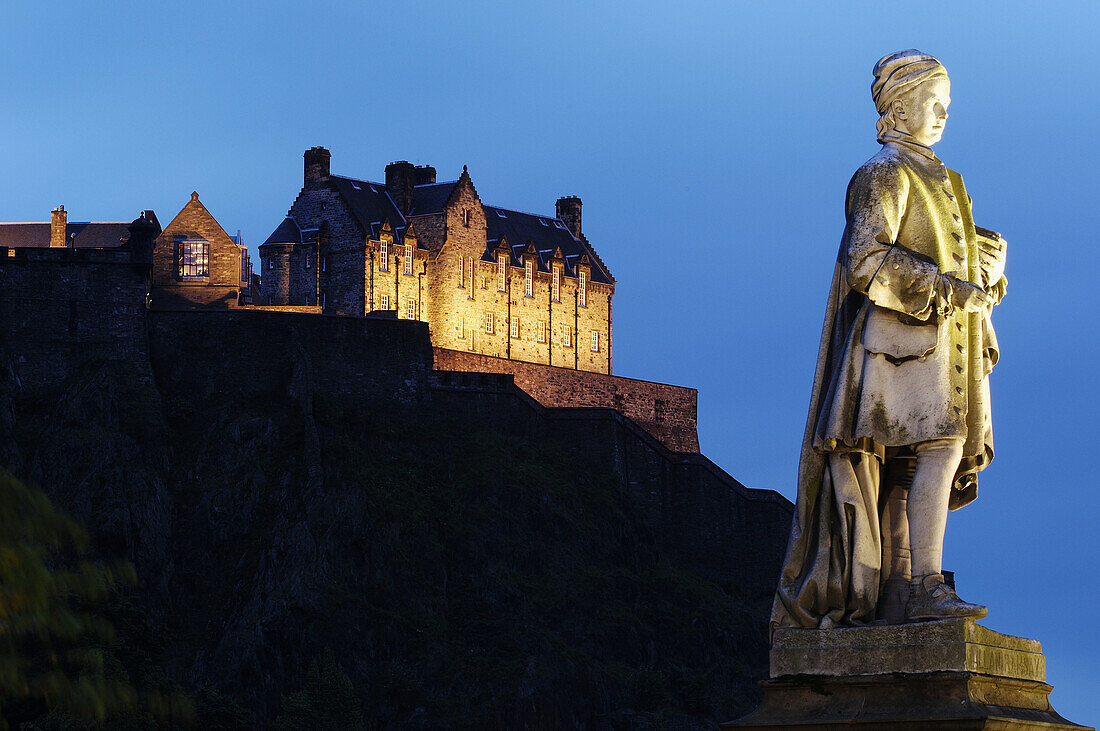 Statue of Allan Ramsay and Edinburgh Castle in background from Princes Street at dusk, Edinburgh. Scotland, UK