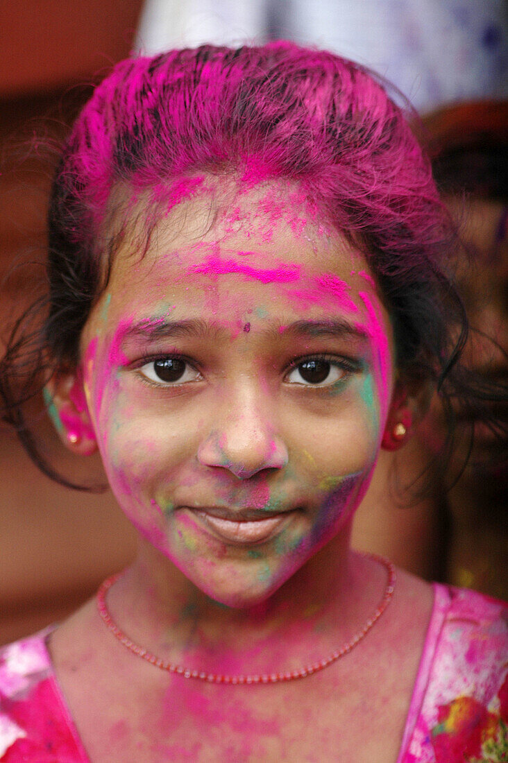 Panjim Goa, India, girl with colored powder on the face during the Holi feast