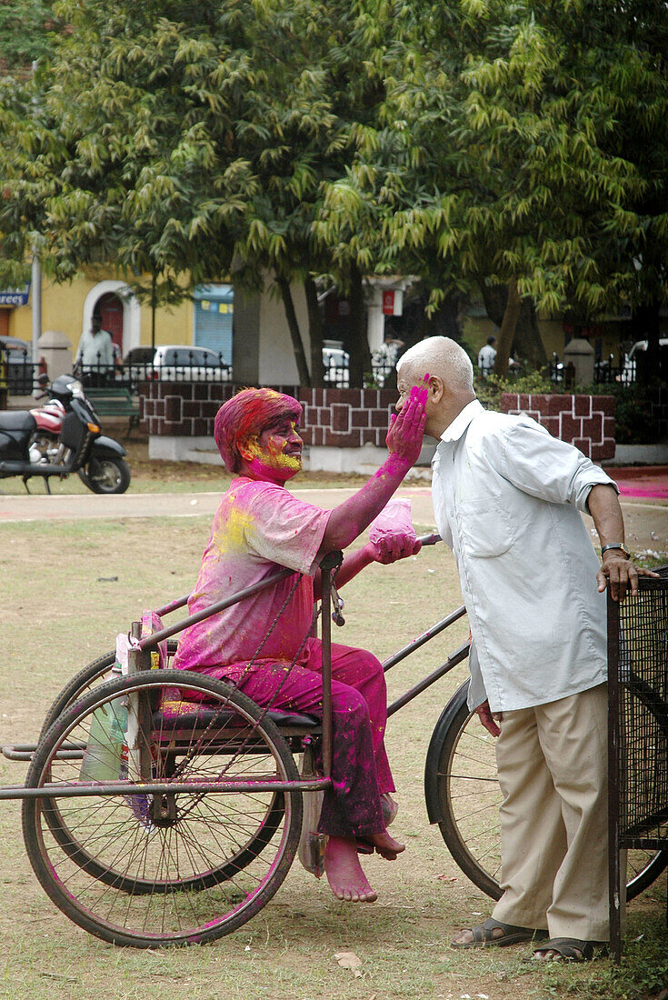 Panjim Goa, India, men putting colored powder on their faces during the Holi feast