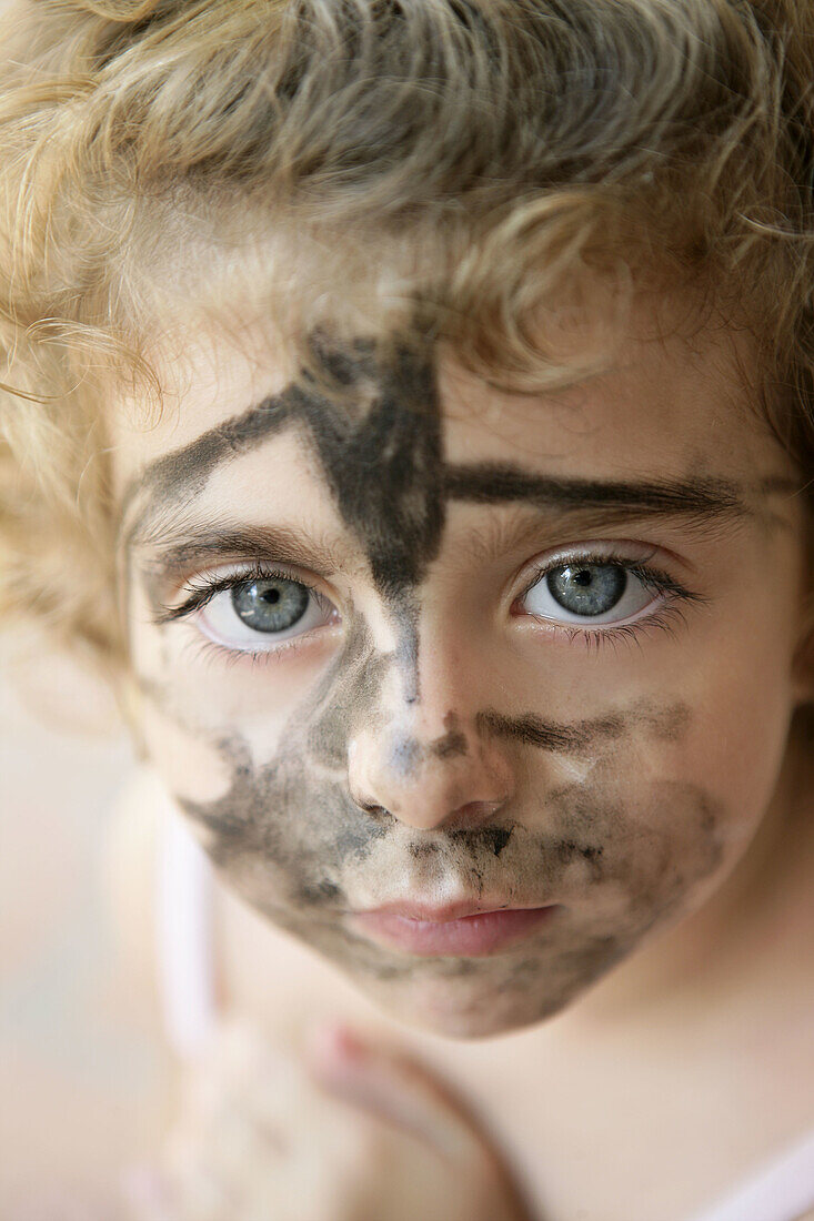 Blue eyes toddler with painted in black face