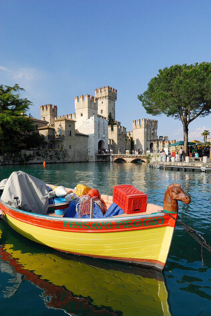 Fishing boat, Castello Scaligero in background, Sirmione, lake Garda, Lombardy, Italy