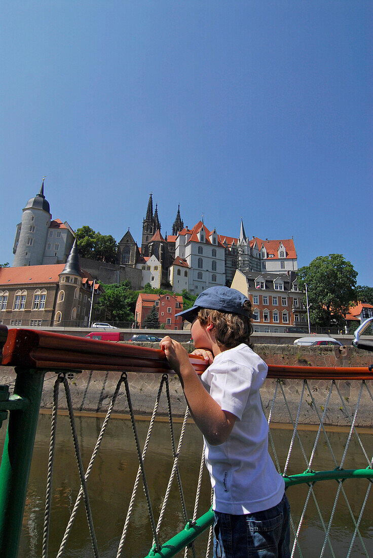 Boy (6 years) on steamboat, castle Albrechtsburg in background, Meissen, Saxony, Germany