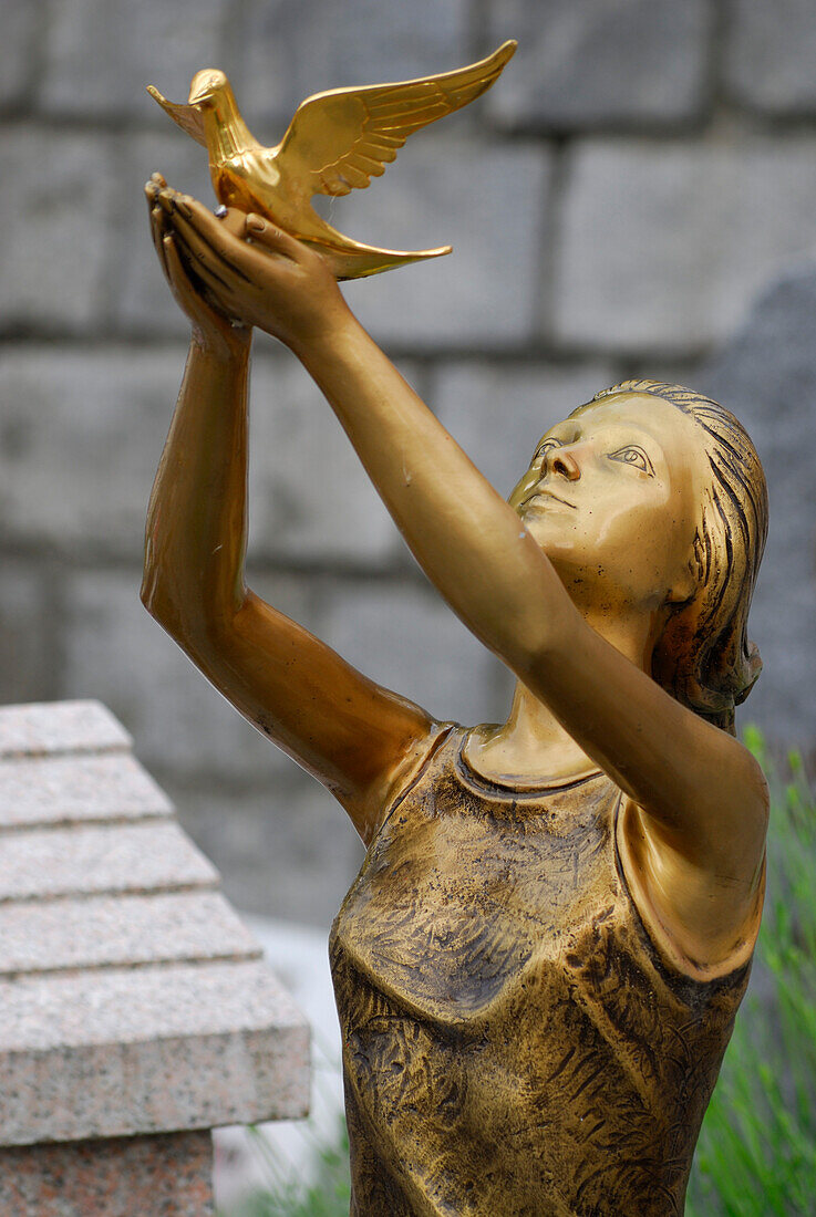 Junge Frau lässt Friedenstaube fliegen, Bronzefigur, Brissago, Lago Maggiore, Tessin, Schweiz