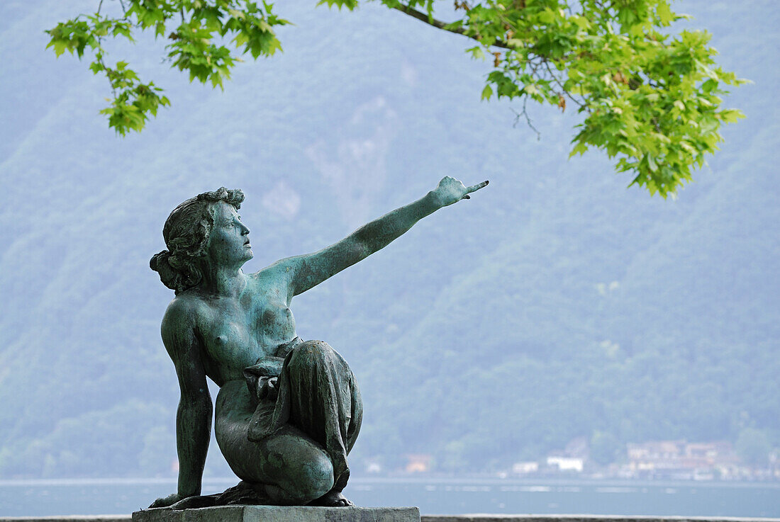 Bronzefigur von junger Frau deutet in die Ferne, Stadtpark von Lugano, Lugano, Tessin, Schweiz