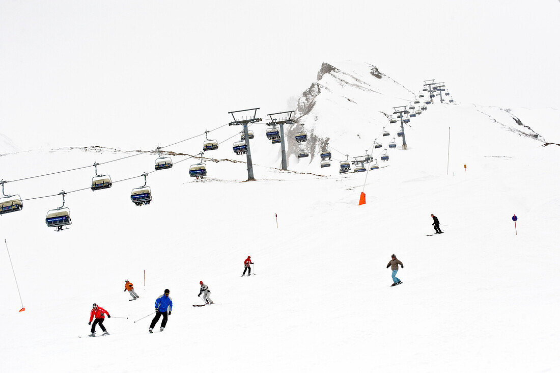 Skiers on slope, chairlift in background, Hintertux, Tyrol, Austria
