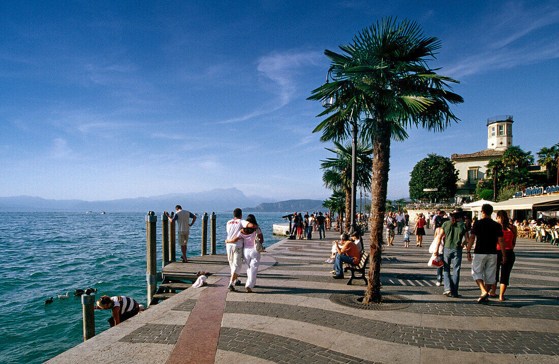 Menschen an der Uferpromenade im Sonnenlicht, Lazise, Gardasee, Venetien, Italien, Europa