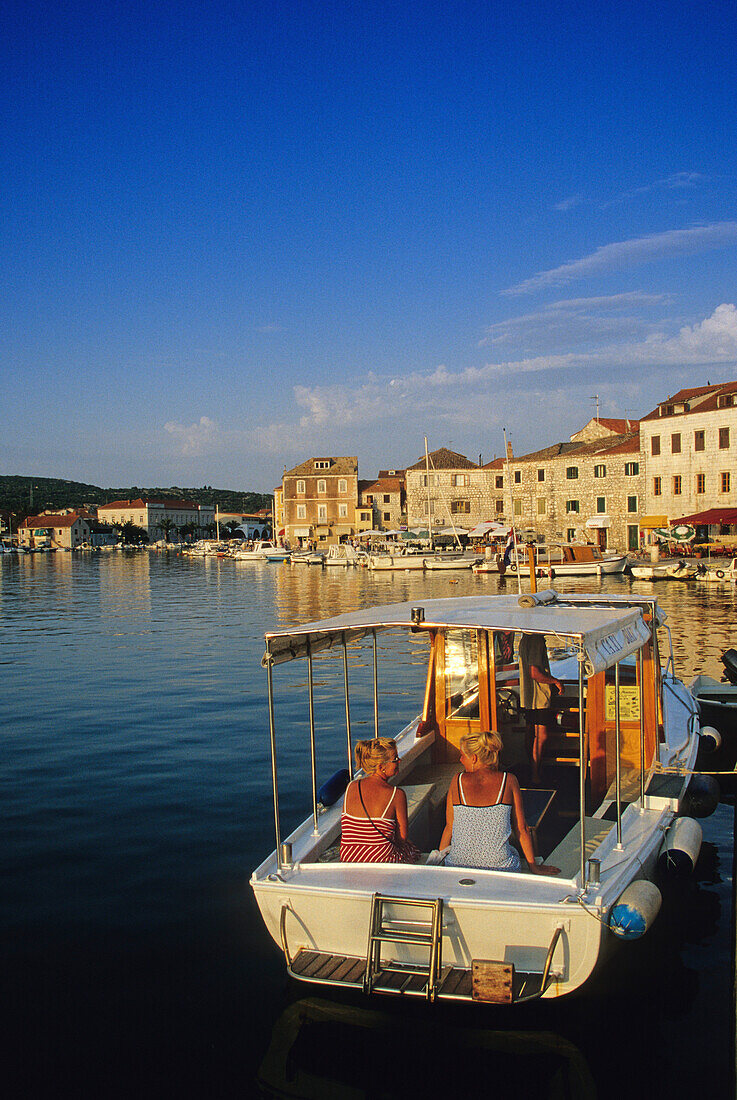 Frauen in einem Boot im Hafen von Stari Grad, Insel Hvar, Kroatische Adriaküste, Dalmatien, Kroatien, Europa