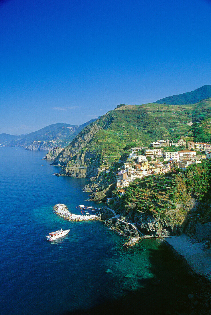 Excursion ship off the rocky coast, view at Riomaggiore, Cinque Terre, Liguria, Italian Riviera, Italy, Europe