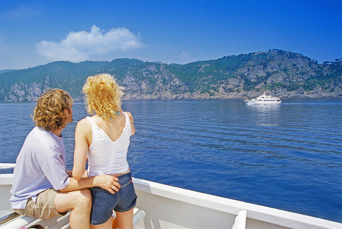 Junges Paar im Ausflugsschiff vor der Küste unter blauem Himmel, Italienische Riviera, Ligurien, Italien, Europa