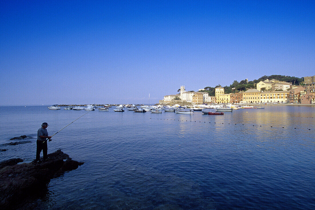 Angler at Baia di Silenzio bay, view at seaport Sestri Levante, Liguria, Italian Riviera, Italy, Europe