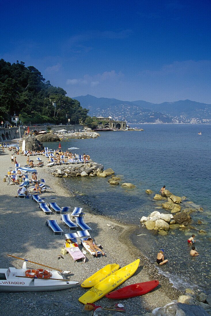 Menschen an einem Badestrand unter blauem Himmel, Ligurien, Italienische Riviera, Italien, Europa