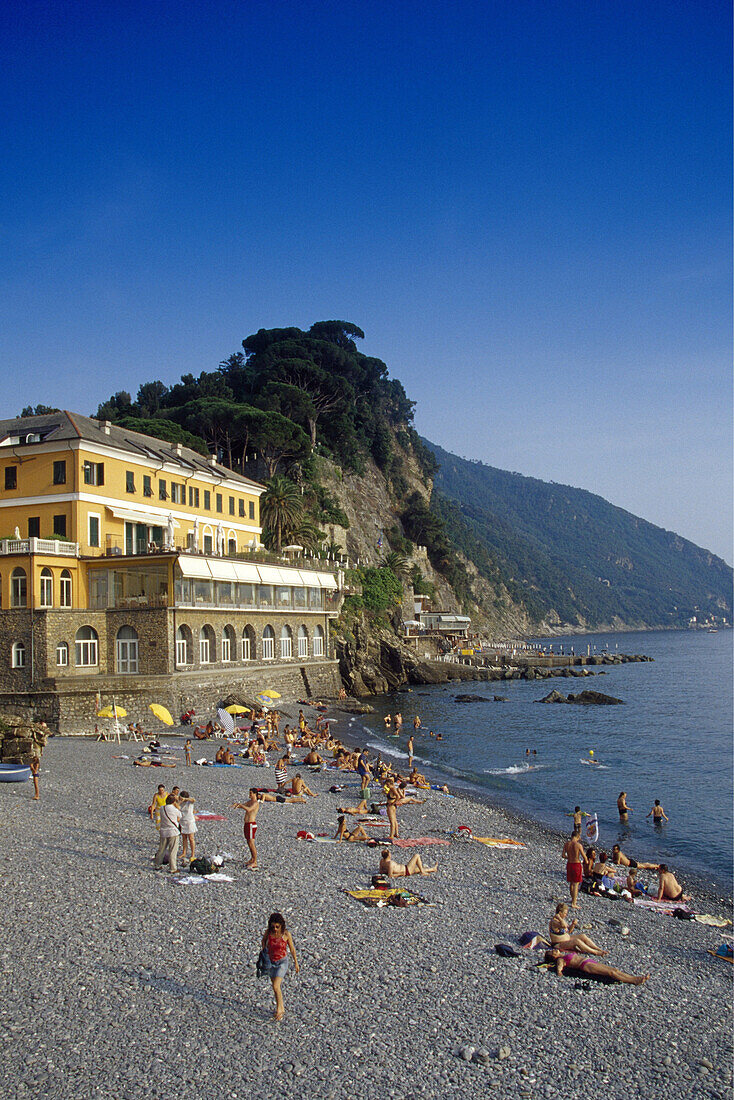 Menschen und Hotel am Strand unter blauem Himmel, Camogli, Italienische Riviera, Ligurien, Italien, Europa