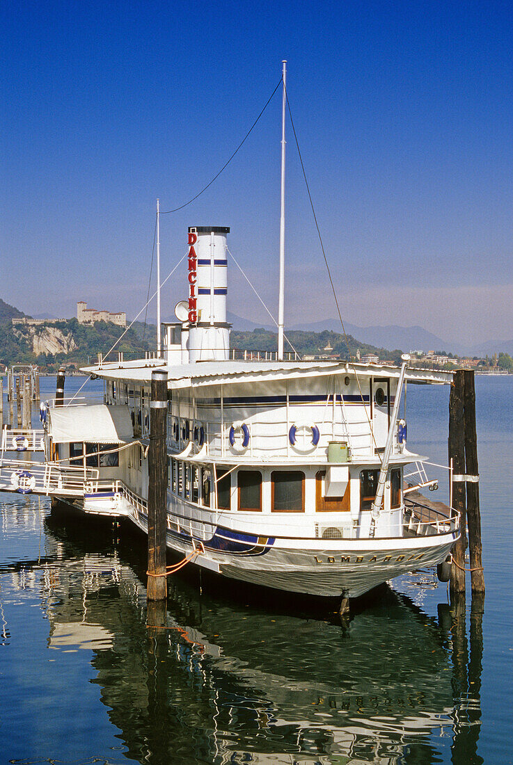 Paddle wheel steamer under blue sky, fort Rocca di Angera in the background, Lago Maggiore, Piedmont, Italy, Europe