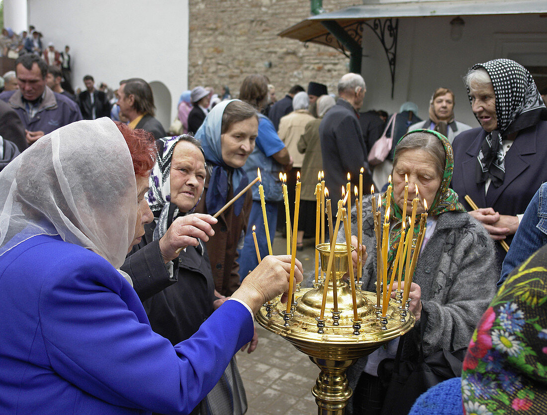 RUSSIA  Lighting candles at  Pechersky the Caves Monastery, Pskov District, founded on August 28th 1473 by Saint Jonah Sheshnik