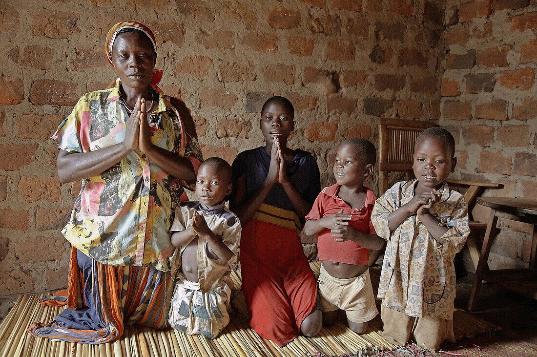 40UGANDA  In the home of Najjemba Teopista, Kasaayi village, Kayunga District  Family praying, from left to right: Teopista, Nakata Maria Goretti, 7, Nankinda Faustea, 13, Waswa Joseph, 7, Lugya Kevin, 5, grandson