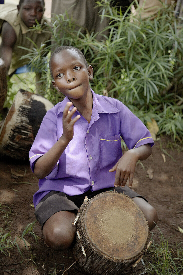 UGANDA  The Kyayaaye Roman Catholic primary school in Kayunga District  Young boy playing drum