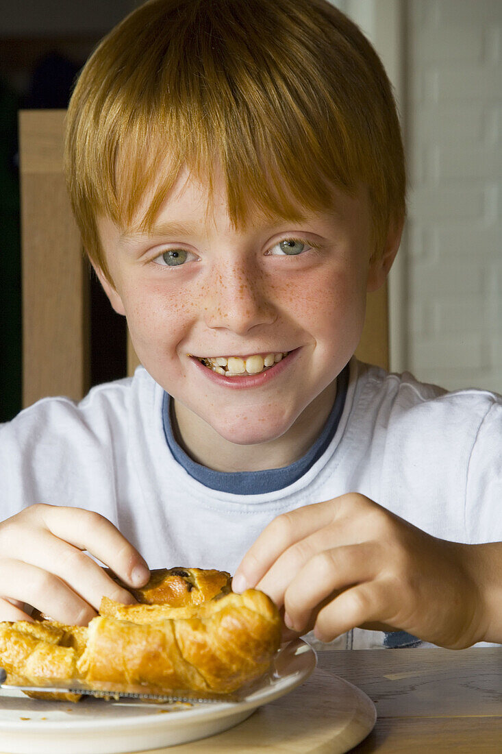 8 yr old boy eating croissants