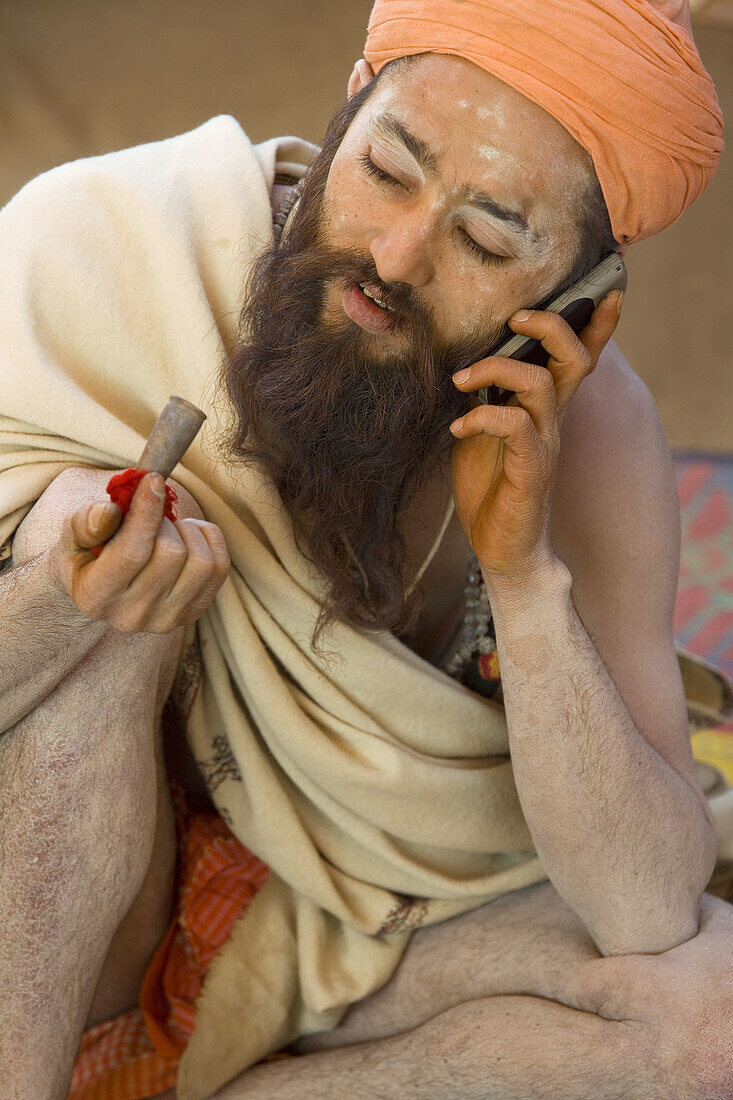 Sadhu with chillum pipe & mobile phone, Allahabad, Uttar Pradesh, India