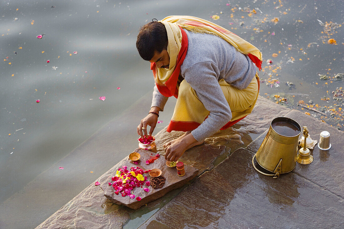 Pilgrim doing puja (Hindu devotional worship) in holy river Ganges, Varanasi, India