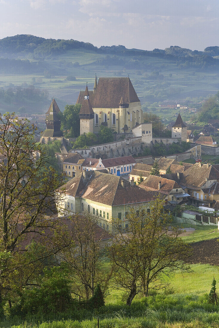 Biertan village with fortified church in morning mist