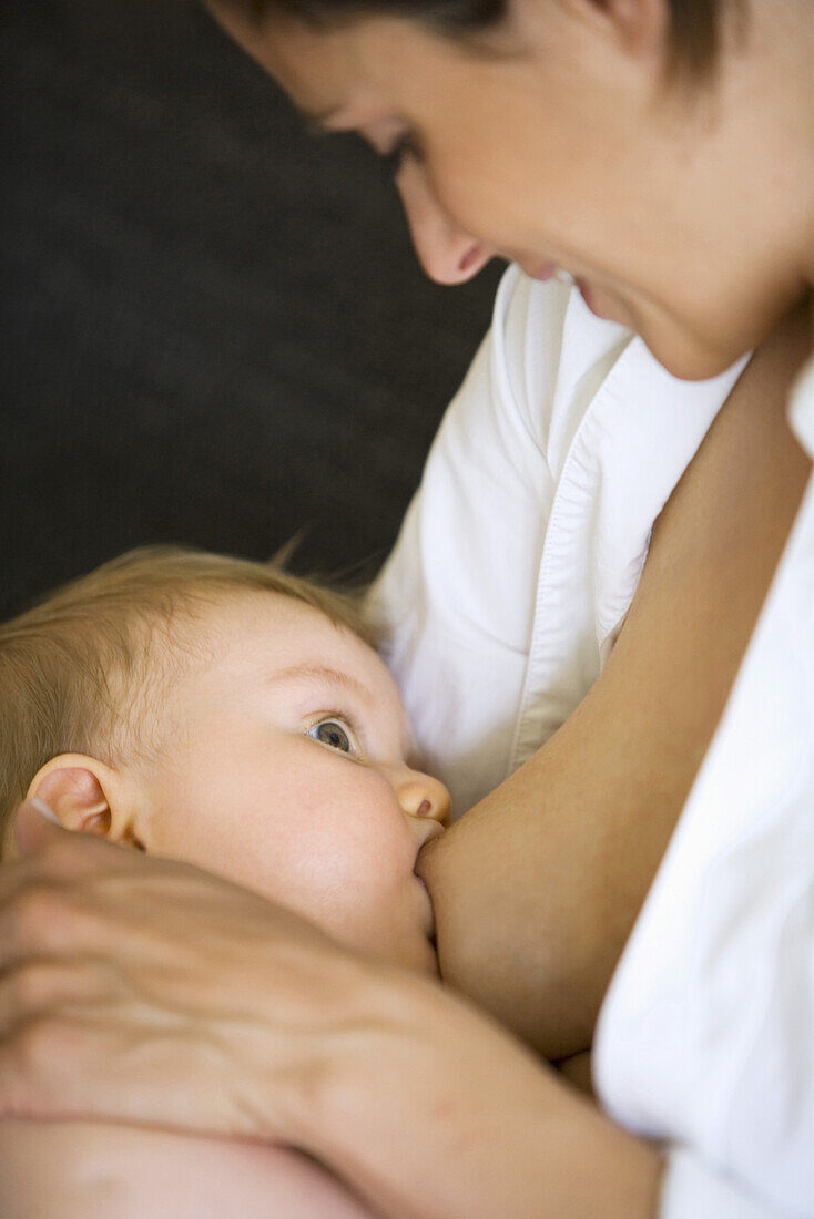 Woman breastfeeding baby girl (8 month), Vienna, Austria