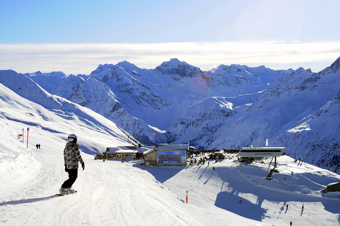 Snowboarderin auf der Piste, Skihütte im Hintergrund, Davos, Graubünden, Schweiz
