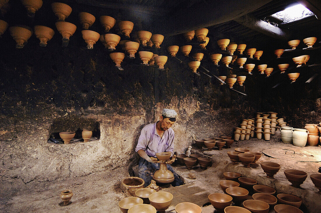 An Uyghur potter concentrating on his work in his studio in Kashgar, China