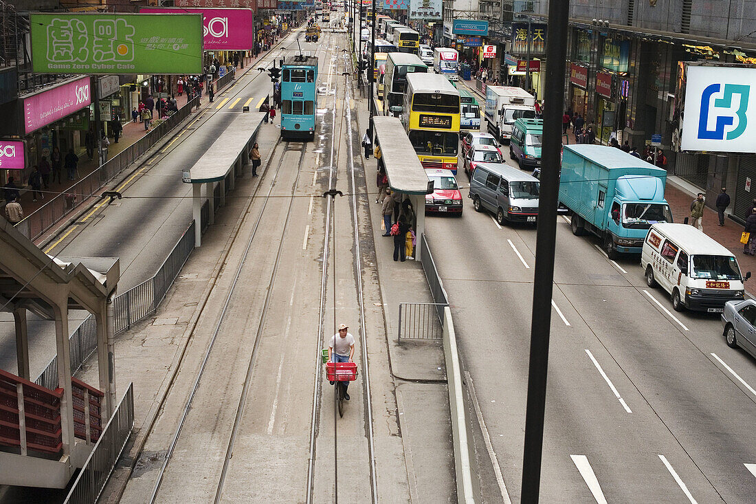 A delivery man taking advantage of the tram way to avoid the congested traffic in Hong Kong, China