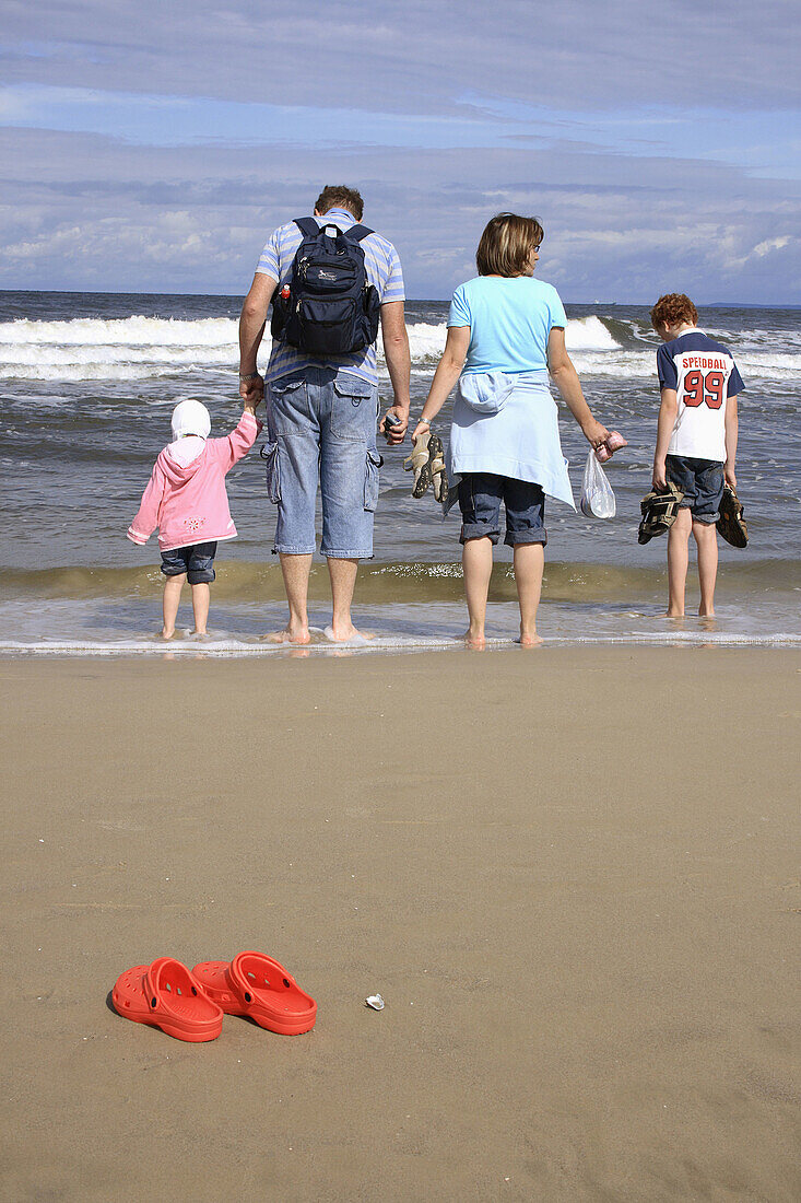 family walking along a sandy beach