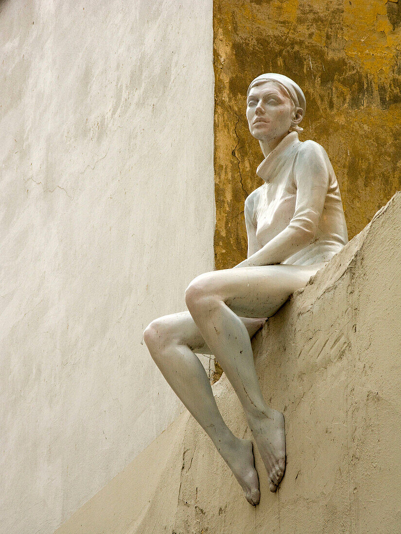 Statue of girl sitting on roof edge ladislav vlna naprstkova stare mesto. Prague. Czech Republic.