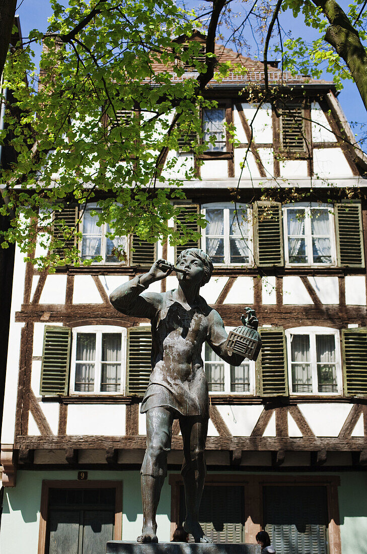 Meiselocker tit bird catcher statue by Ernst Weber and half-timbered house, Place Saint-Etienne, Strasbourg, Alsace, France