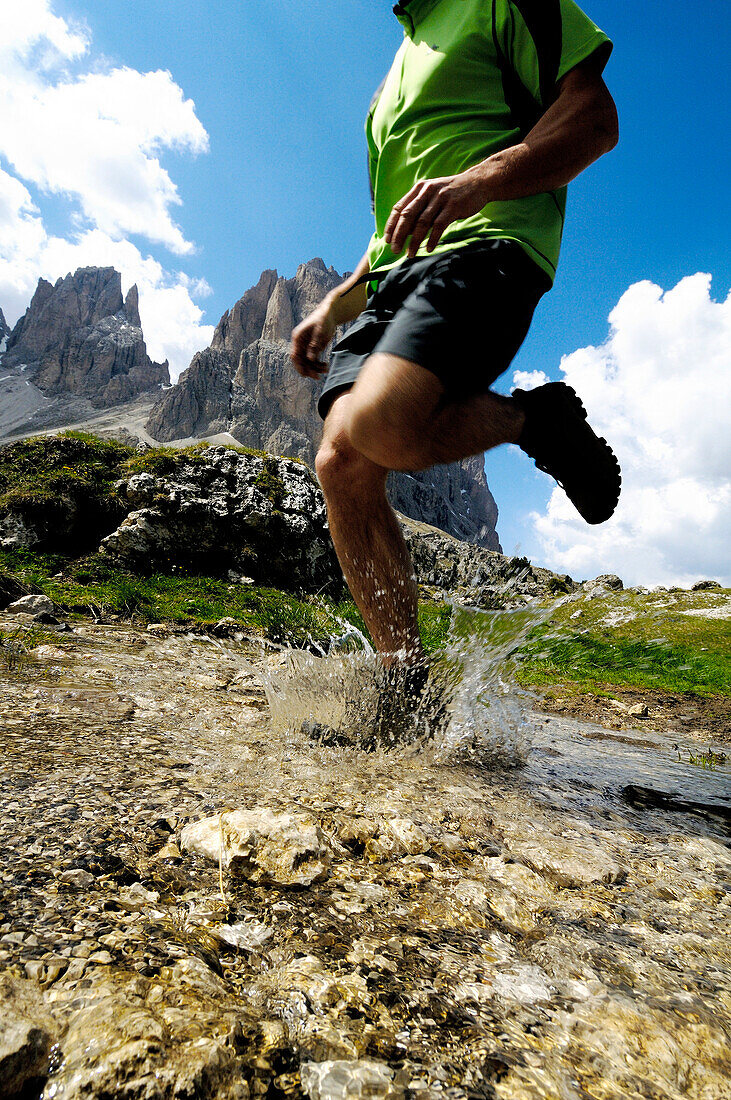 Mann läuft durch einen Gebirgsbach, Dolomiten, Südtirol, Italien, Europa