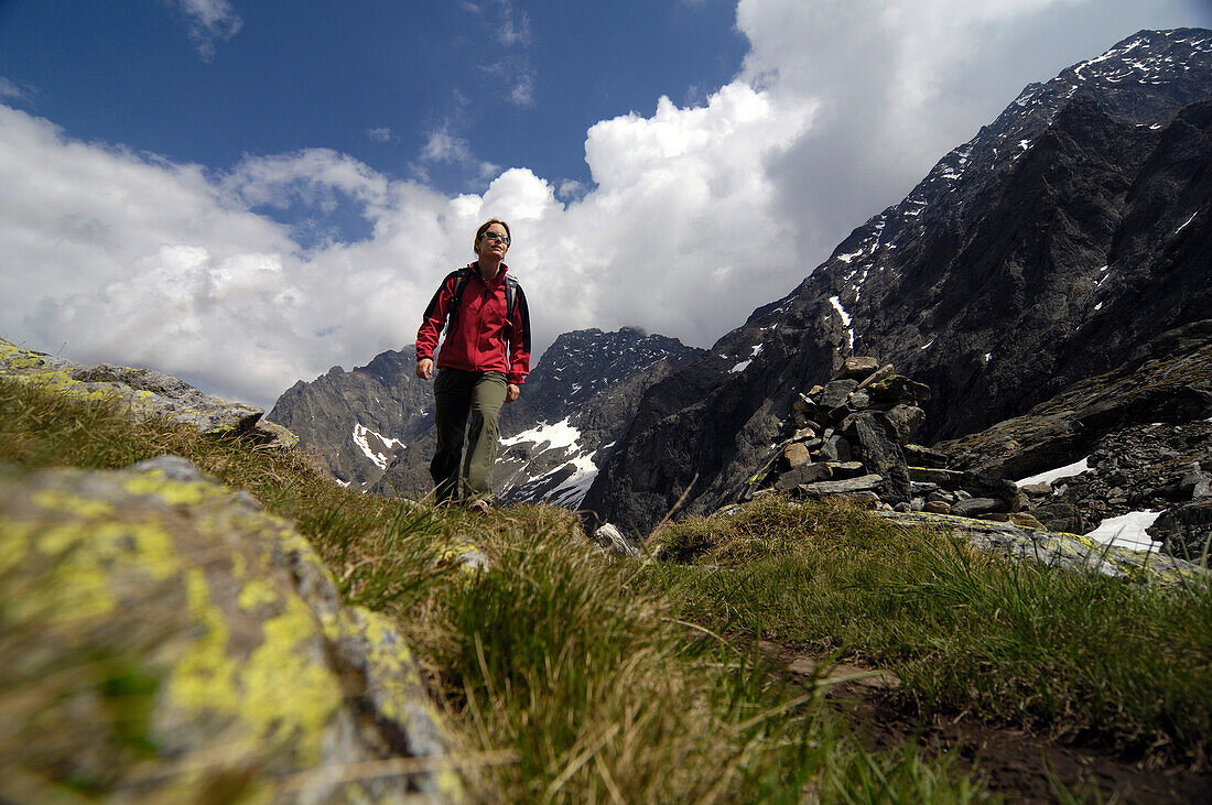 Woman at hike in the mountains in front of white clouds, Hohe Tauern, Austria, Europe