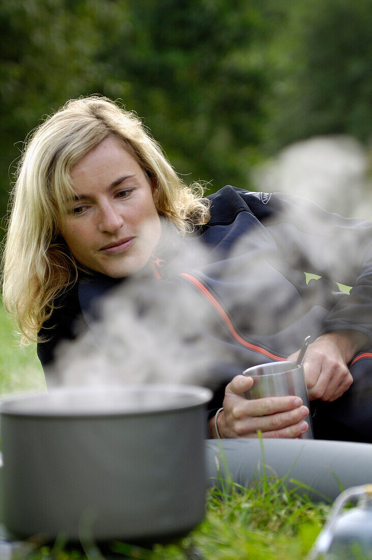 Camping, cooking pot and blonde woman on a meadow, Franconian Switzerland, Bavaria, Germany, Europe