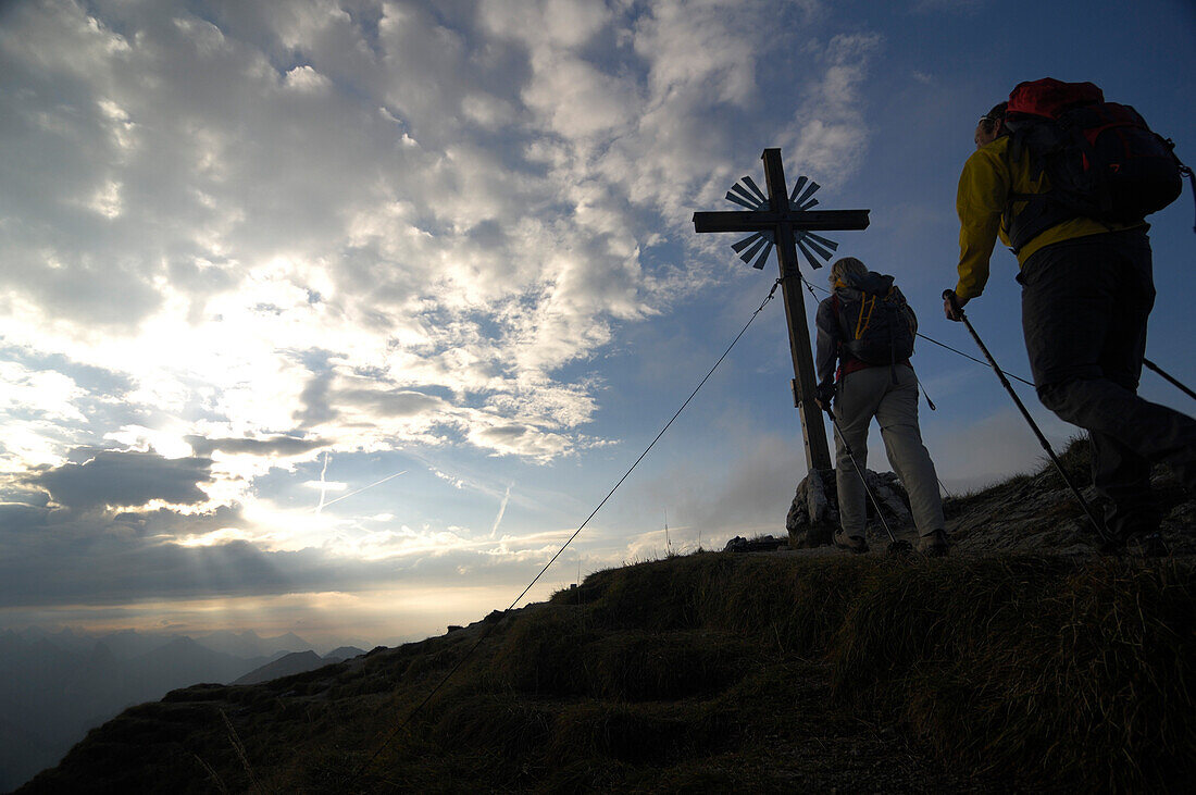 Two people at the summit cross, ascent to Klammspitze, Ammergau Alps, Ammergau, near Oberammergau, Bavaria, Germany