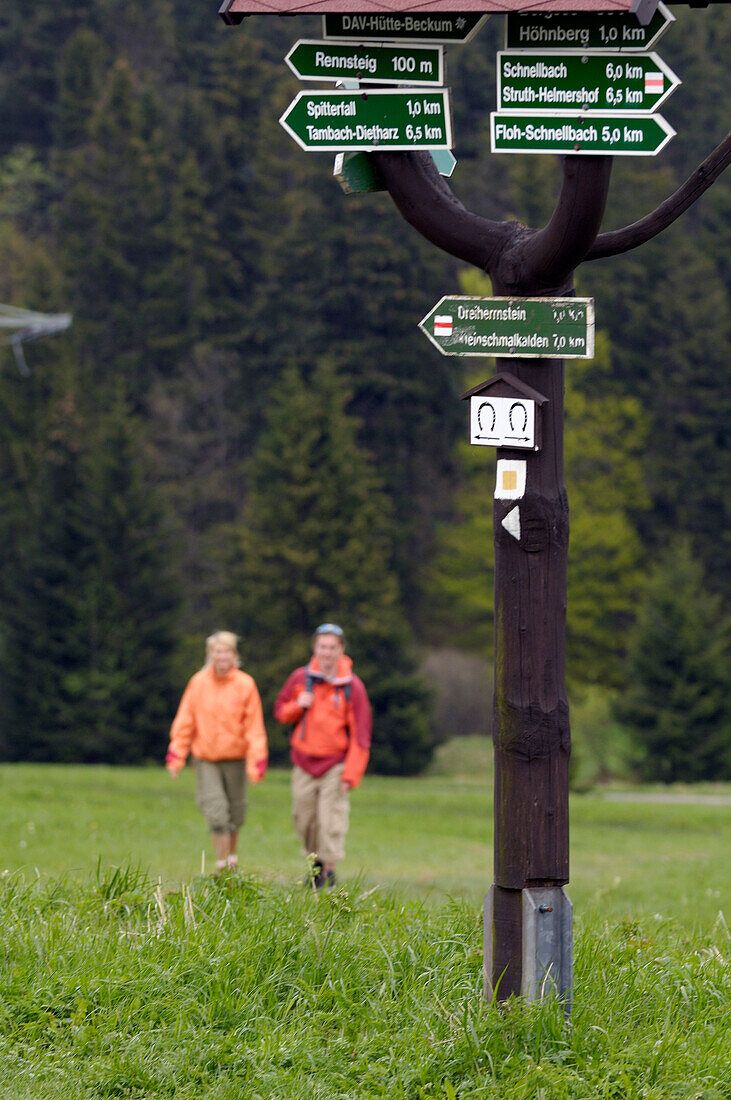 Couple hiking in theThuringian Forest, Signpost, near Tambach Dietharz, Thuringia, Germany