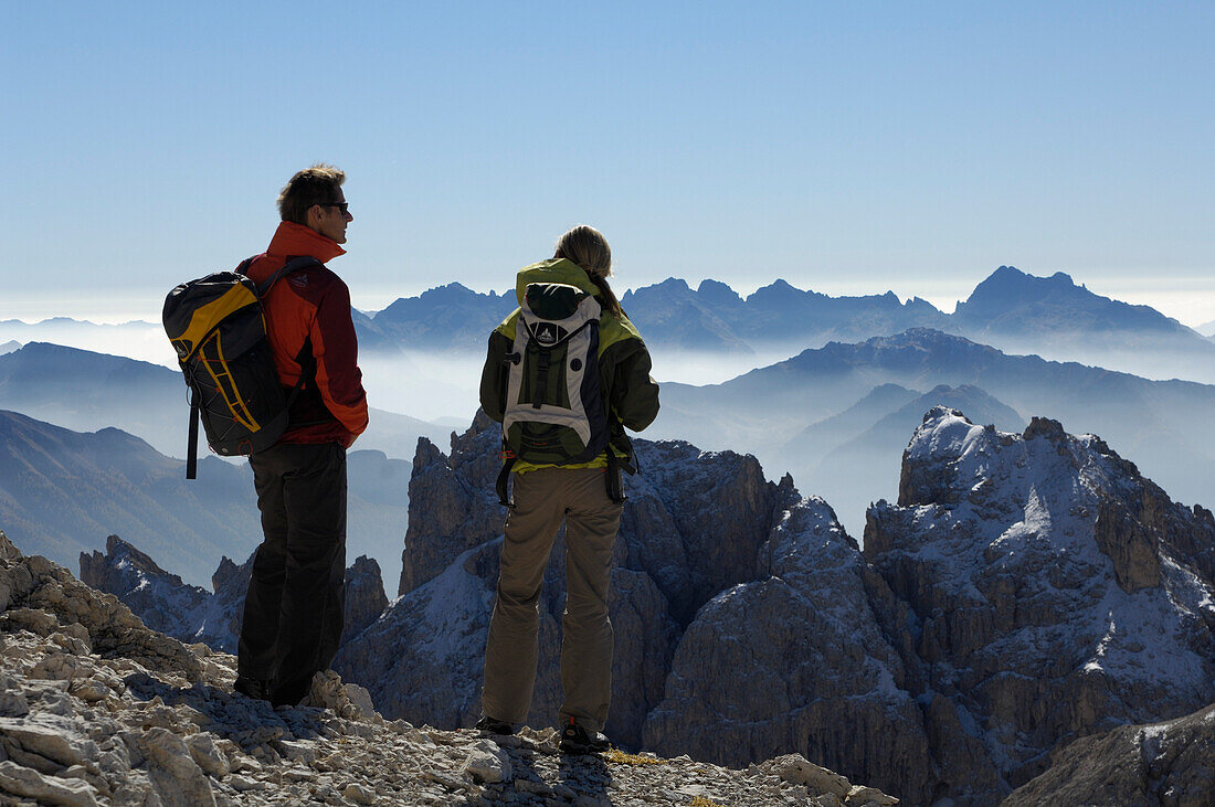 Couple admiring the view, hiking in the mountains, Val di Fassa, Rosengarten, Dolomites, Trento, South Tyrol, Italy